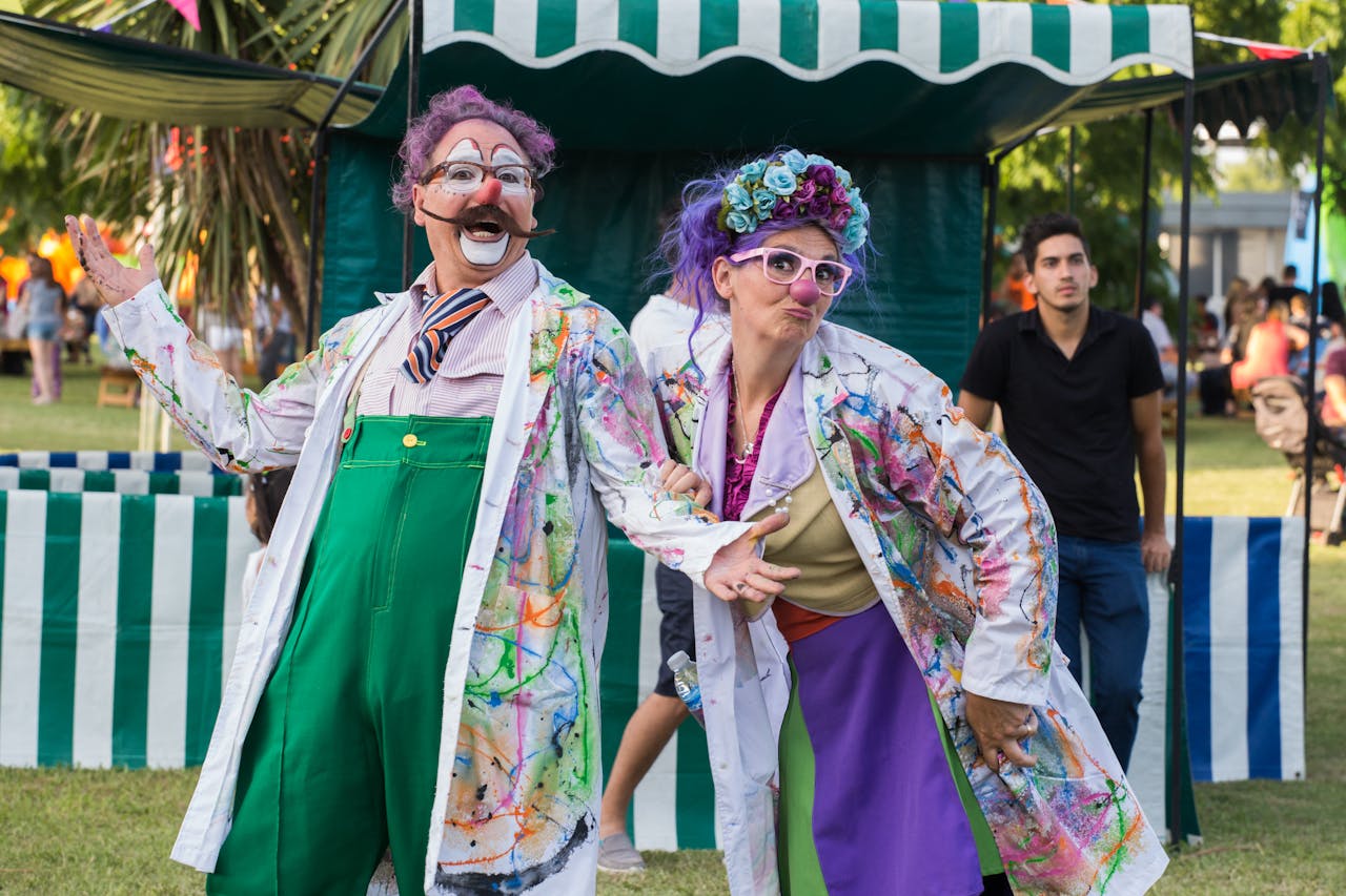 Vibrant clowns entertaining at a lively outdoor festival.